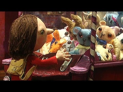 3D animation image.  A little girl gazes at toys within a 'grabber' arcade machine.